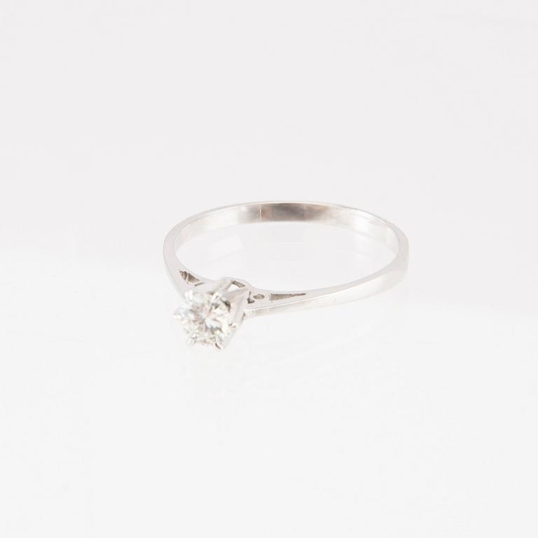 An 18K white gold solitaire ring set with a round brilliant-cut diamond.