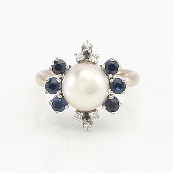 Ring in 14K white gold with a cultured pearl, round single-cut diamonds, and round faceted sapphires.