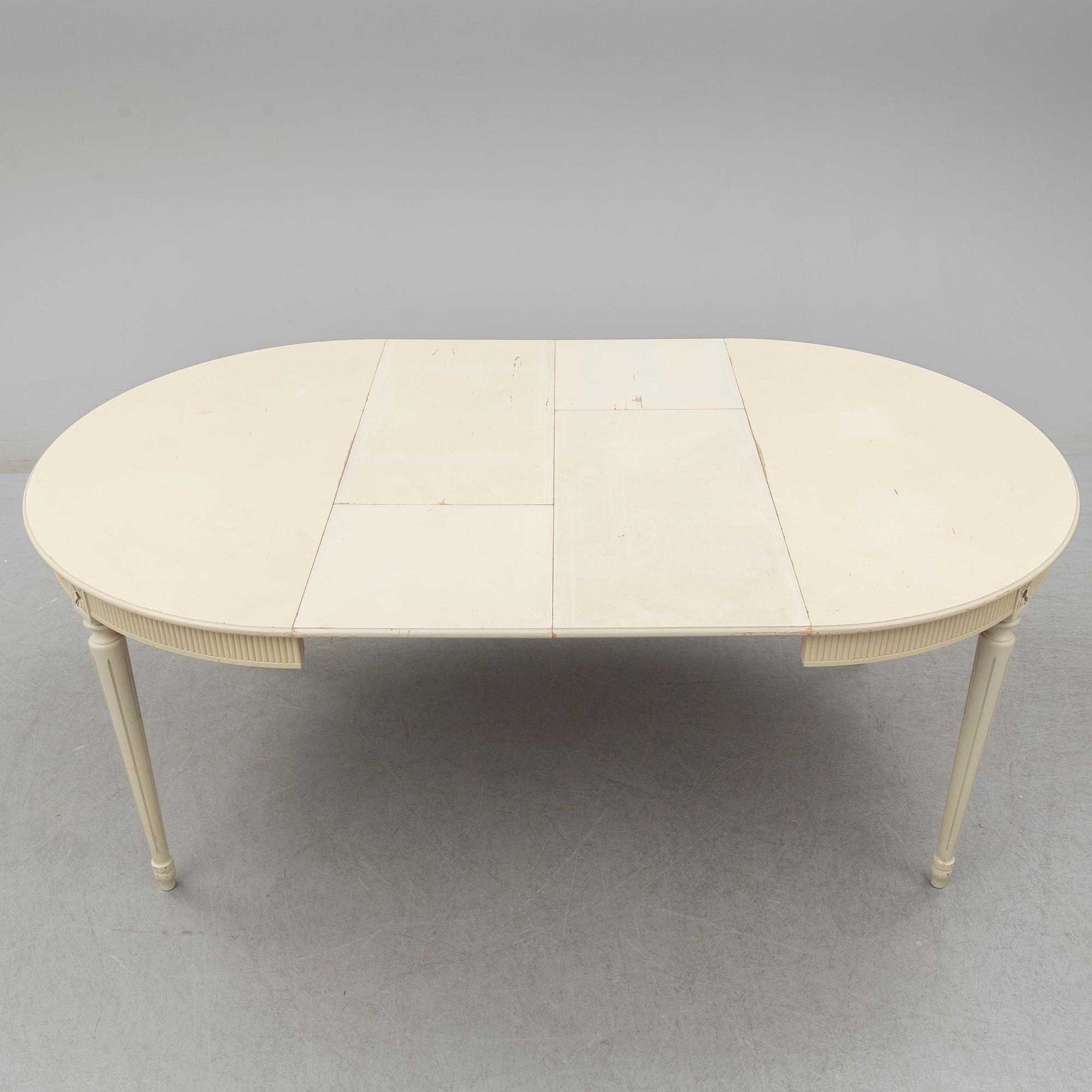 A set of eight chairs and a dining table. Gustavian style, second half of the 20th century. 2 leaves included.