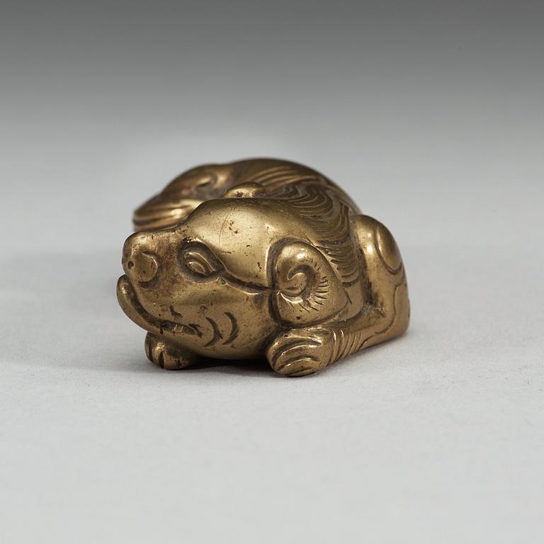 A bronze paper-weight modeled as a reclining lion, Qing dynasty, presumably 18th Century.