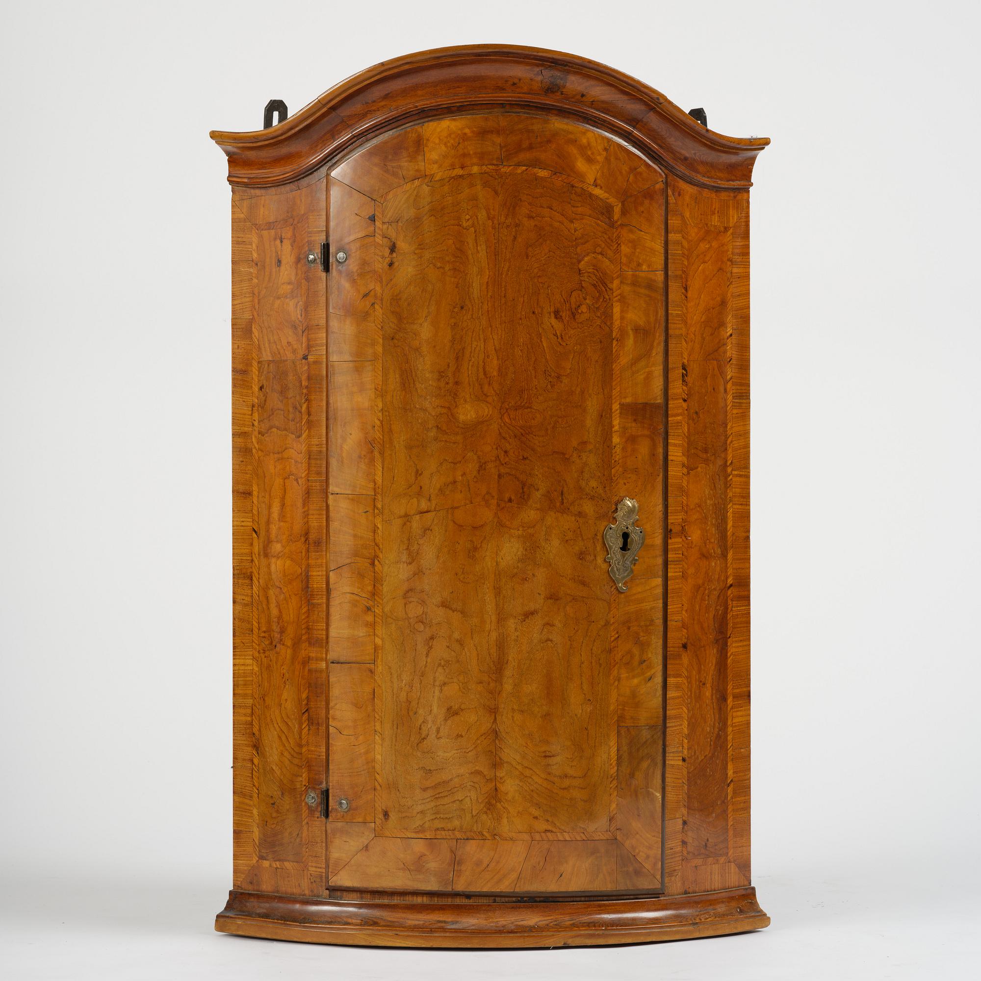 A Swedish late baroqu elm-veneered corner hanging cabinet. first part 18th century.