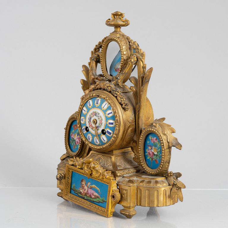 A Louis XVI style mantel clock and a pair of candelabra, circa 1900.