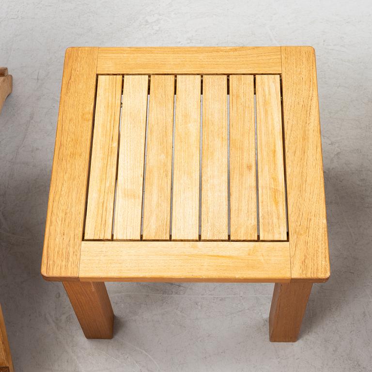 A pair of teak deck chairs and a table, 21st Century.