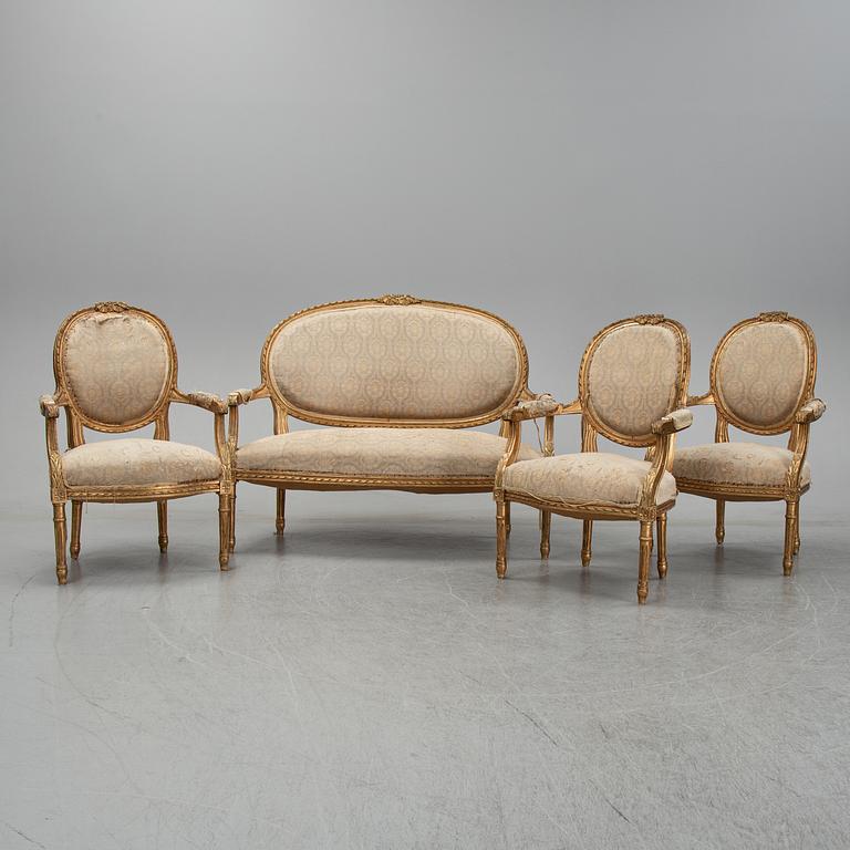 An early 20th century Louis XVI-style sofa and three chairs.