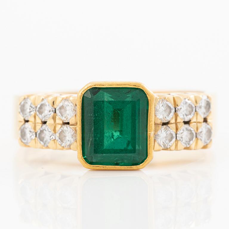 Ring 18k guld med en fasettslipad smaragd och runda briljantslipade diamanter.