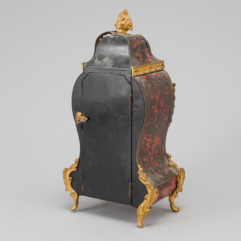 A Louis XV-style mantle clock with console base.