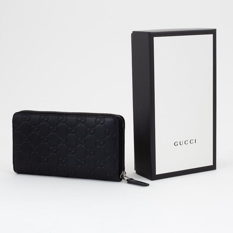 Gucci, an embossed böack leather wallet.