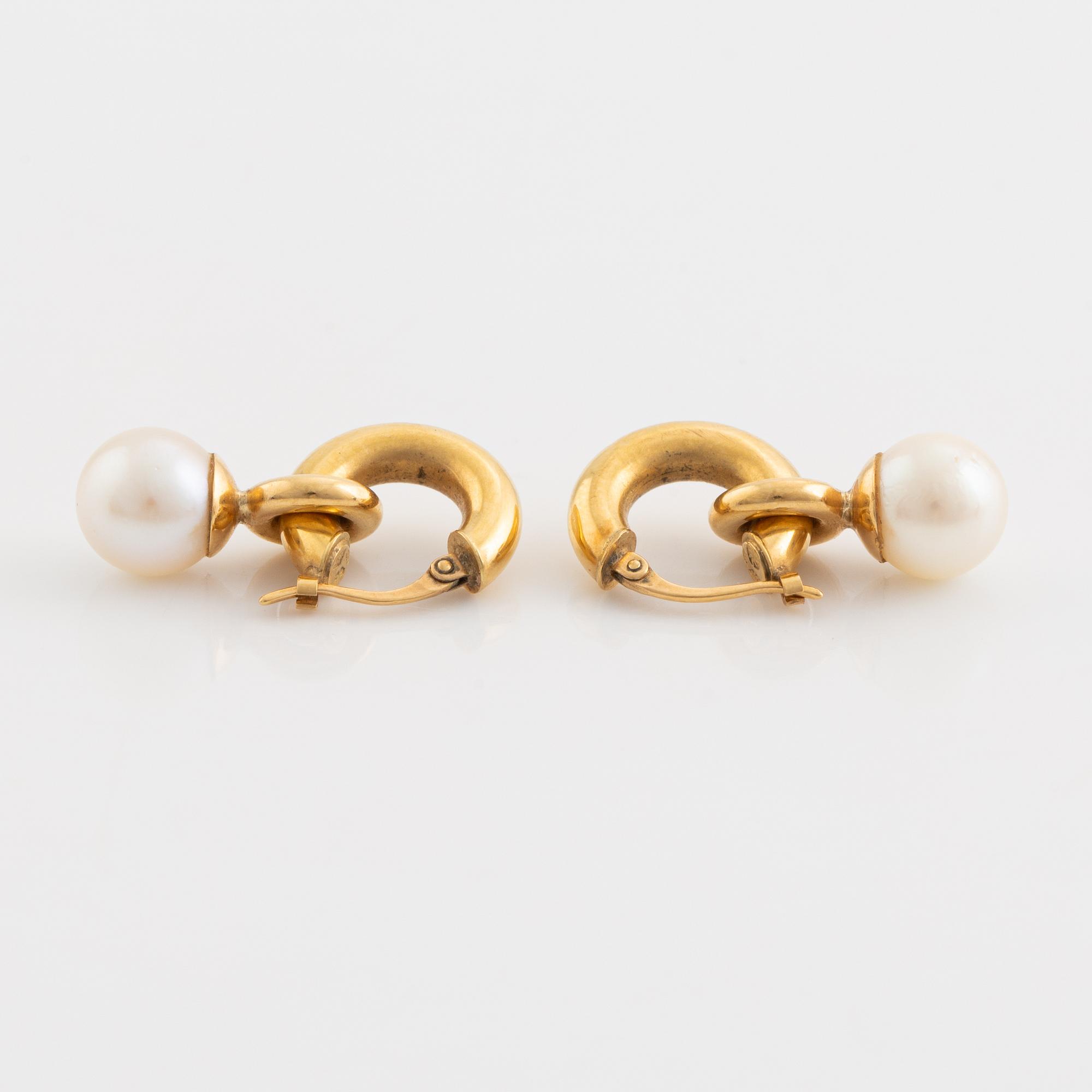 A pair of gold earrings with pearls.