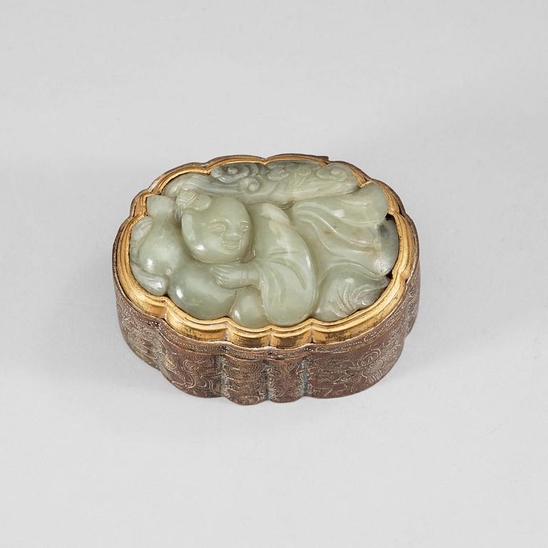 A partly gilded metal box with cover, mounted with a carved pale celadon nephrite plaque. Late Qing dynasty (1644-1912).