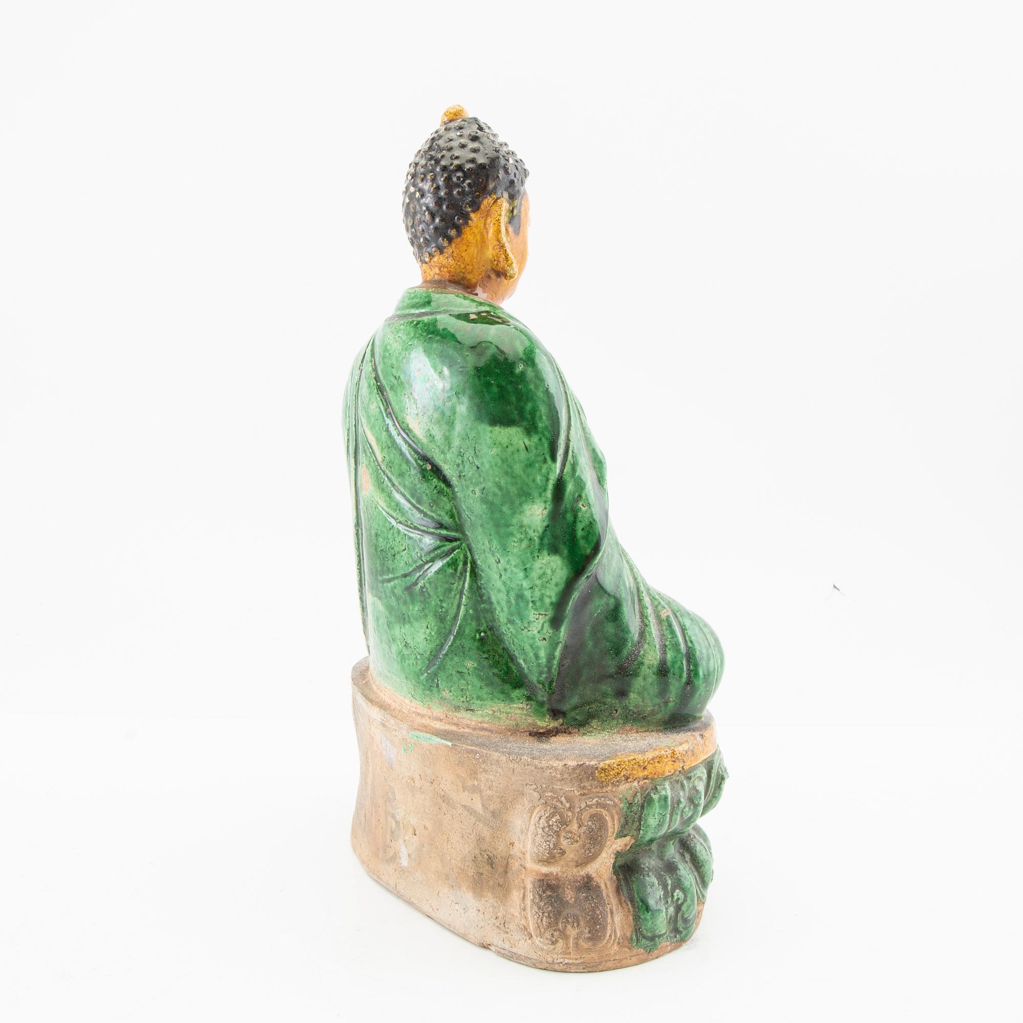 A green and yellow glazed figure of buddha, China, 20th century.