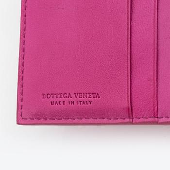 Bottega Veneta, a cerise leather wallet.