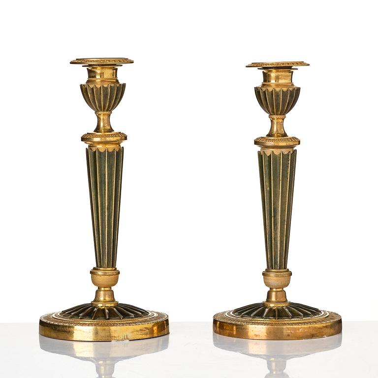 A pair of French Empire ormolu and patinated bronze candlesticks, early 19th century.