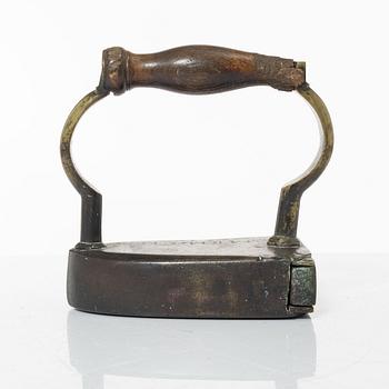 A brass clothes iron, dated 1710.