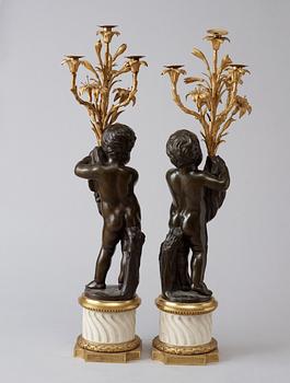 A pair of Louis XVI-style 19th century gilt and patinated bronze marble four-light candelabra.