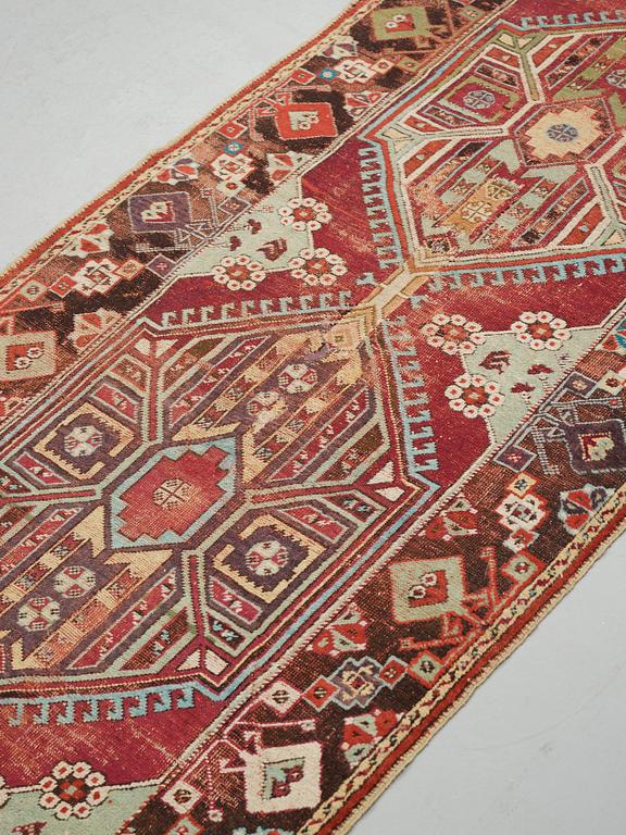 A RUNNER, an antique Anatolian, ca 425 x 101-107 cm (as well as 2,5 cm light green flat weave at one end).