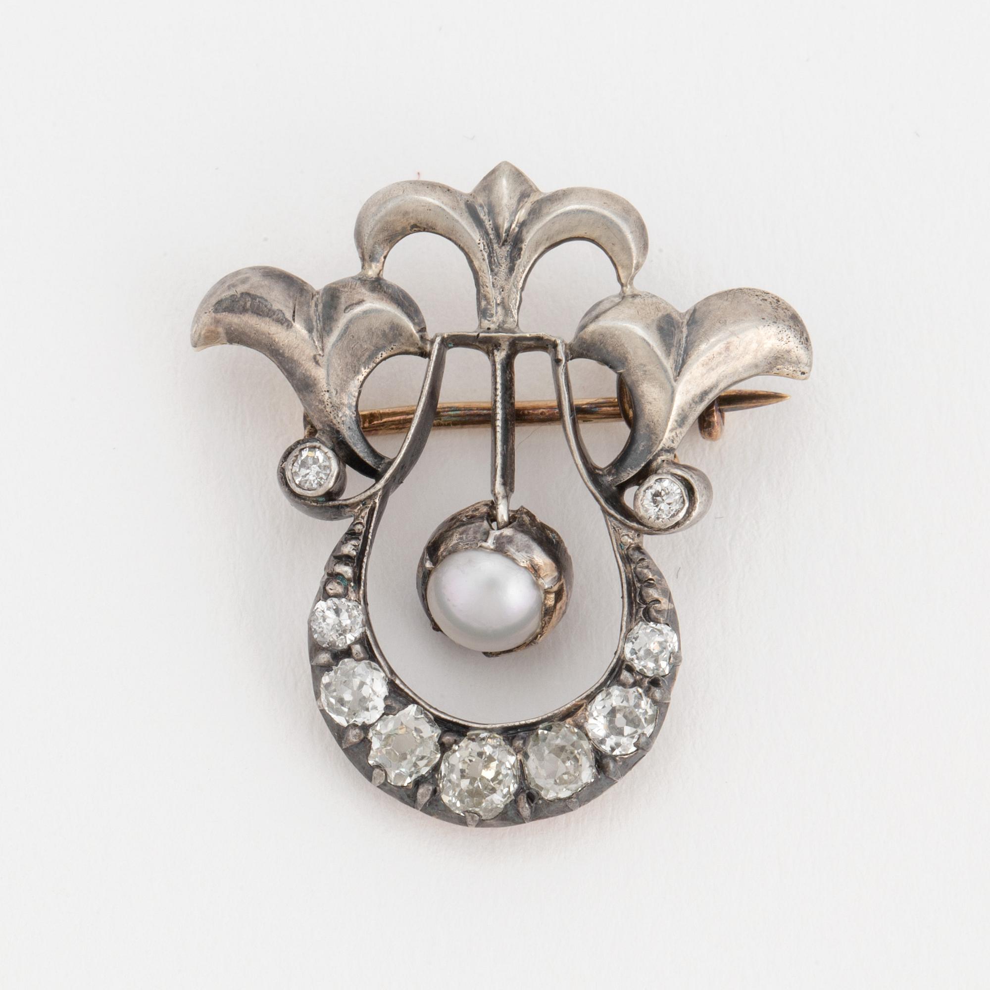 A brooch set with a mabé pearl and old-cut diamonds.