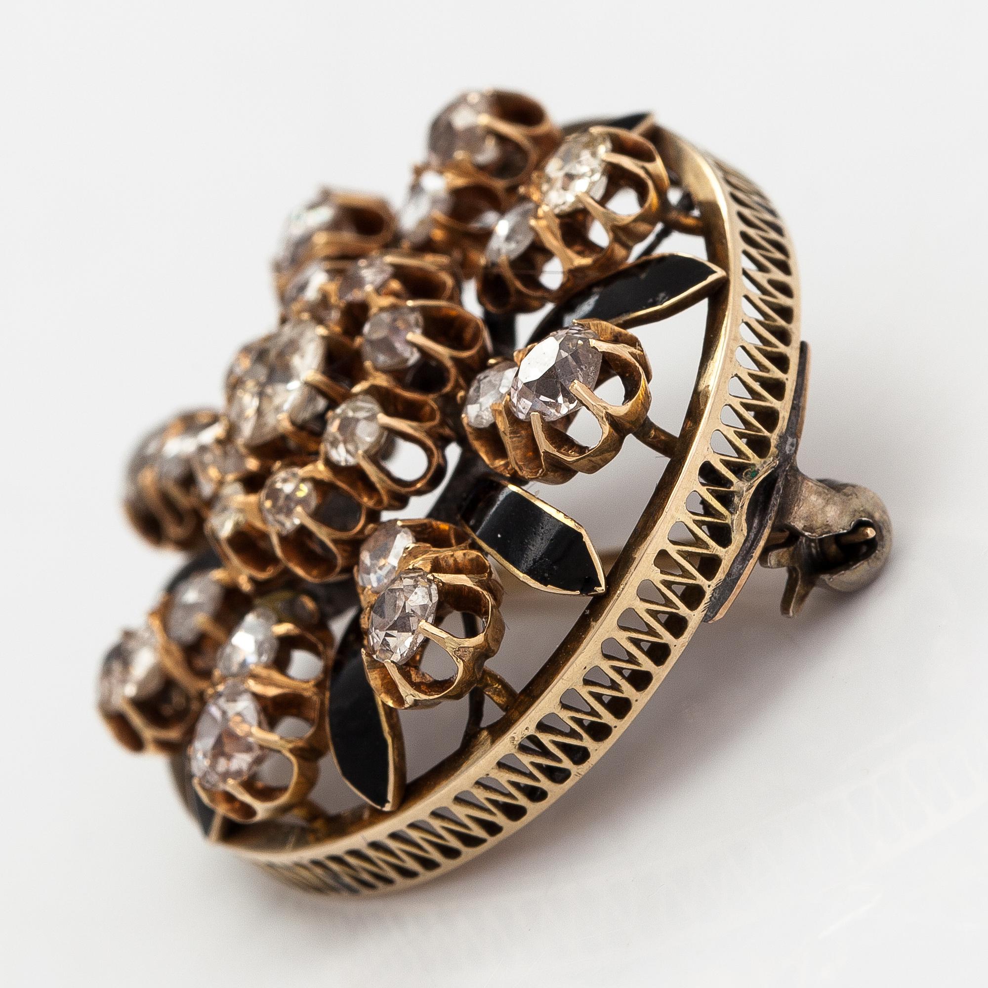 A 12K gold brooch with enamel and old- and rose- cut diamonds.