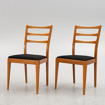 A dining table with four chairs, mid 20th century.