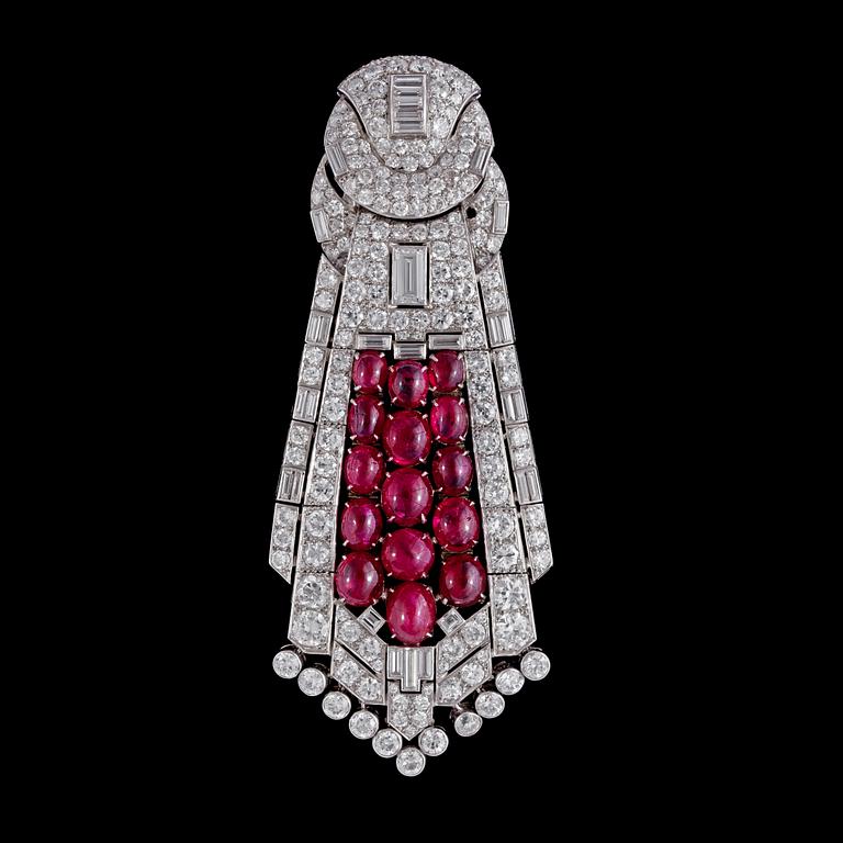 HÄNGE/BROSCH, cabochonslipade rubiner, tot. ca 39.50 ct, smaragd- och briljantslipade diamanter, ca 23 ct. 1930-tal.