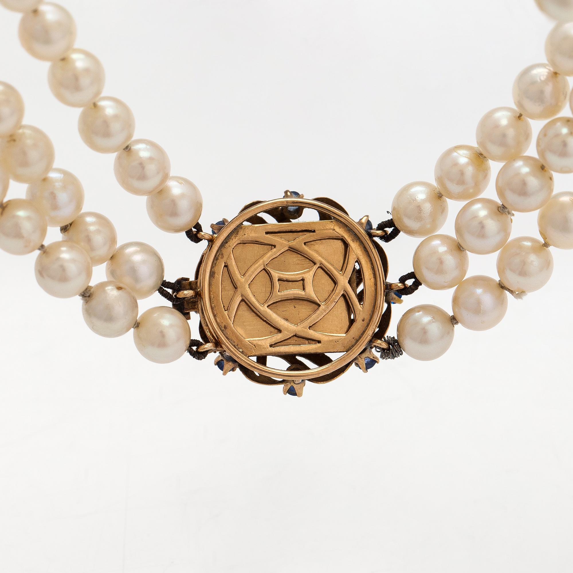 Helminauha, 3-rivinen, 17K kultaa, viljellyt helmet, 17K kultaa, aitoja ja synteettisiä safiireja.