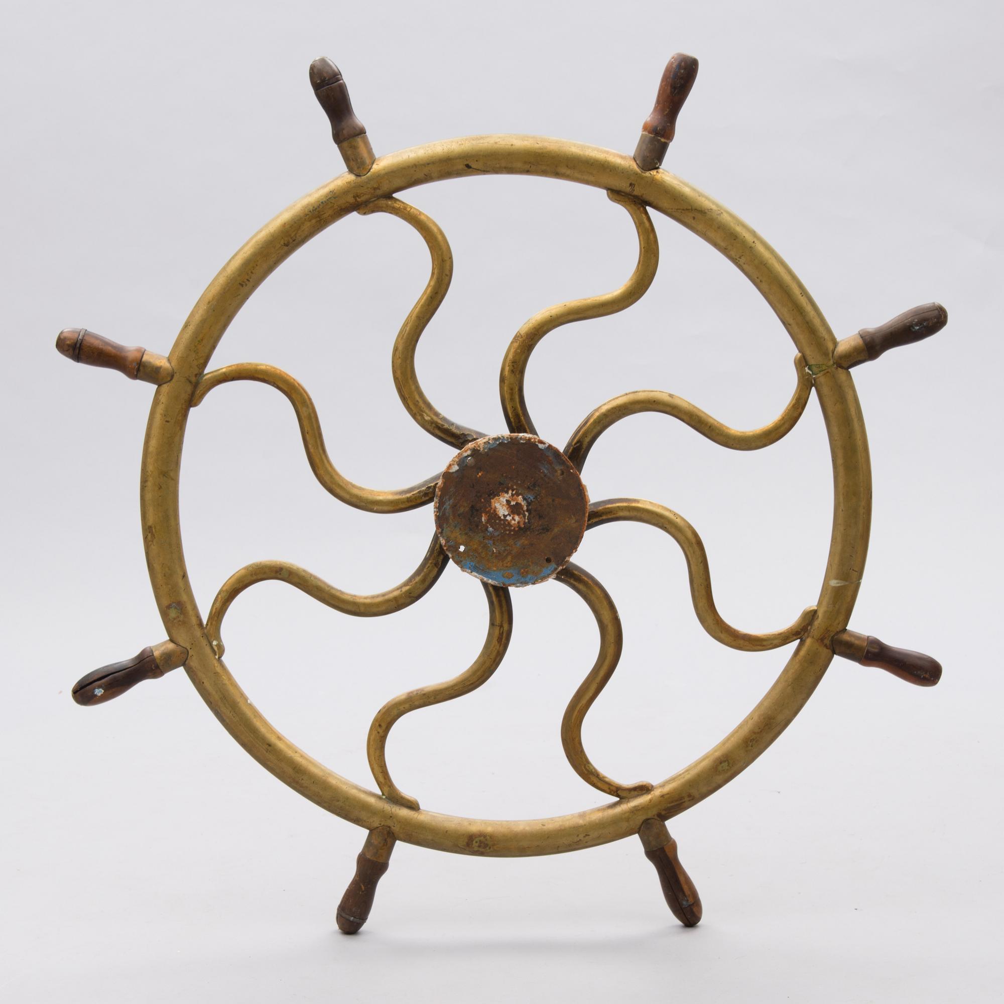 A ship's brass steering wheel, circa 1900.