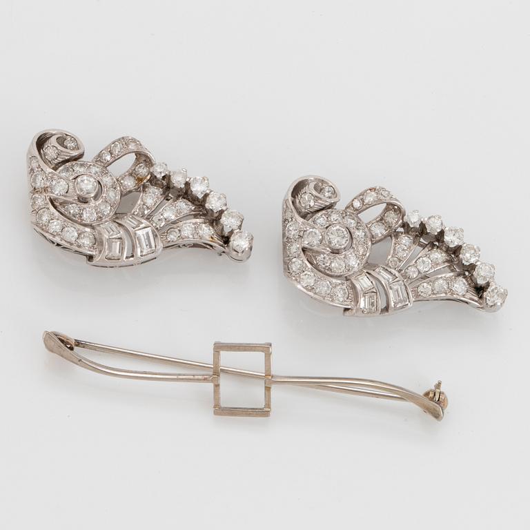 Dubbelclip/brosch platina med runda briljant-, smaragd- samt åttkantslipade diamanter.