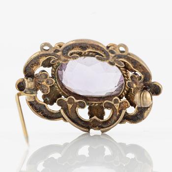 Brooch, gilded metal with a faceted amethyst.