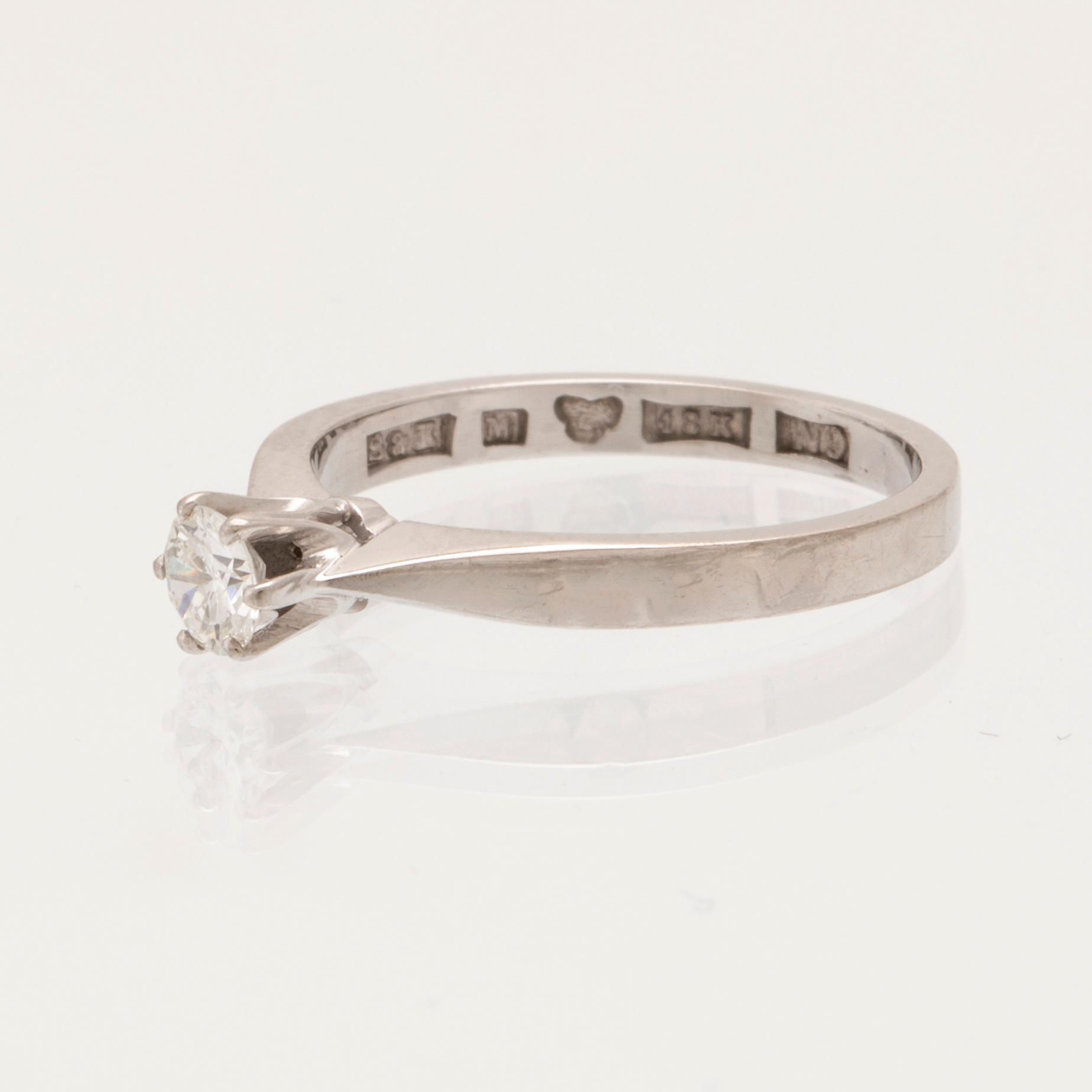 Ring 18K vitguld med en rund briljantlipad diamant, Sjögren & Komstadius Malmö 1963.