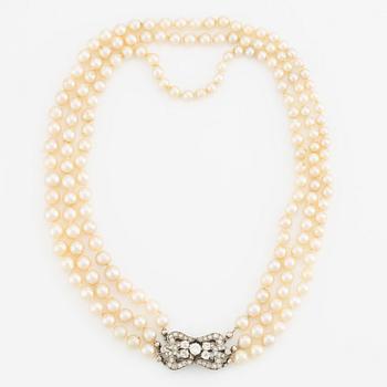 A three-strand cultured pearl necklace with an 18K white gold clasp with round brilliant-cut diamonds.