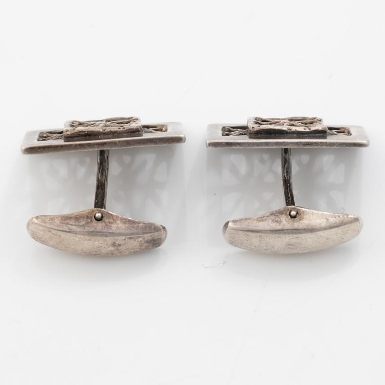 Four silver jewellery pieces: three brooches and a pair of cufflinks. With rose quartz and tiger’s eye. Finnish designers.