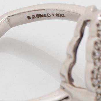 A platinum ring set with a faceted sapphire and round brilliant-cut diamonds.