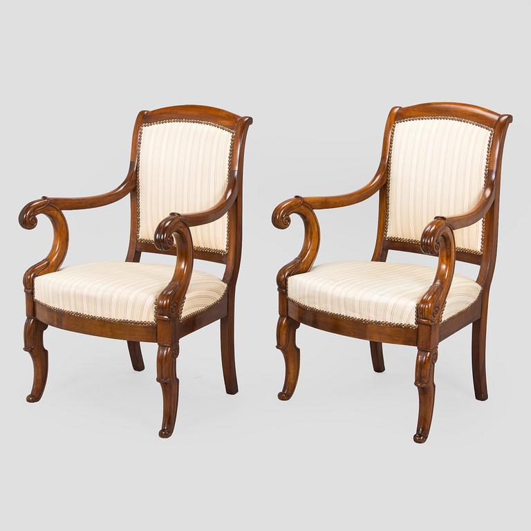 A pair of French open-arm chairs, first half of the 19th century.
