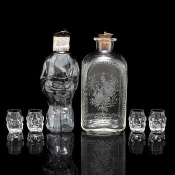 Two glass bottles and four vodka glasses,