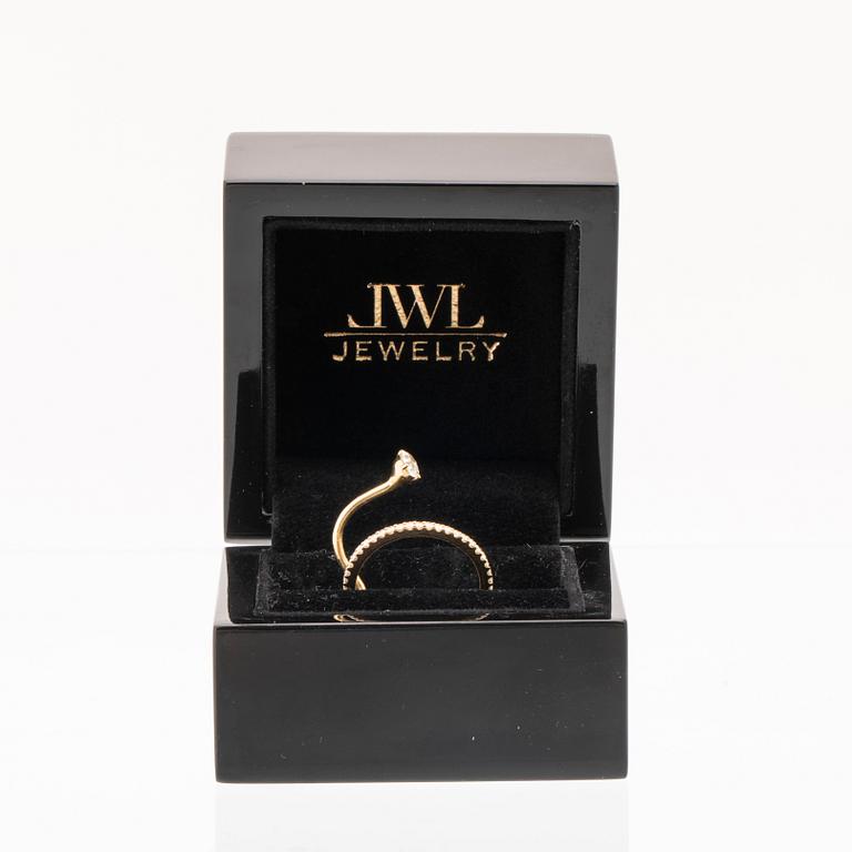 An 18K gold ring set with an oval cut and round brilliant cut diamonds by LWL Jewelry.