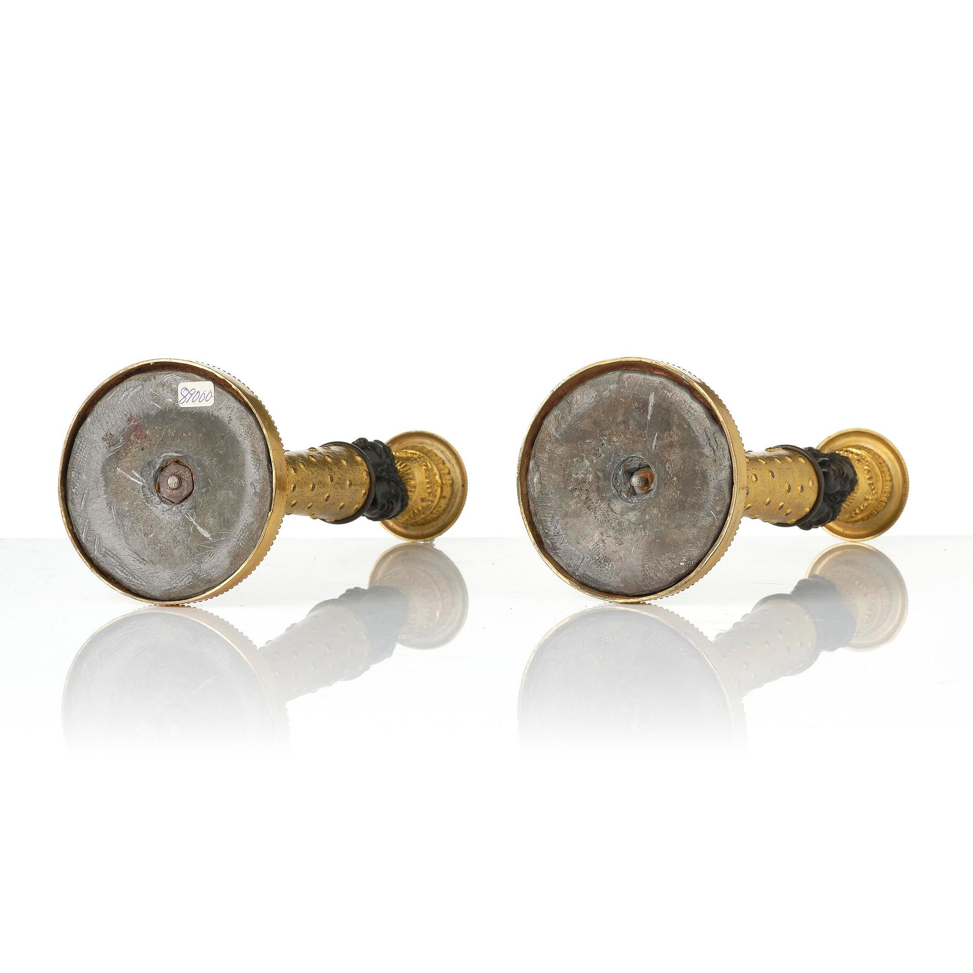 A pair of Napoleon III gilt and patinated bronze candlesticks, later part 19th century.