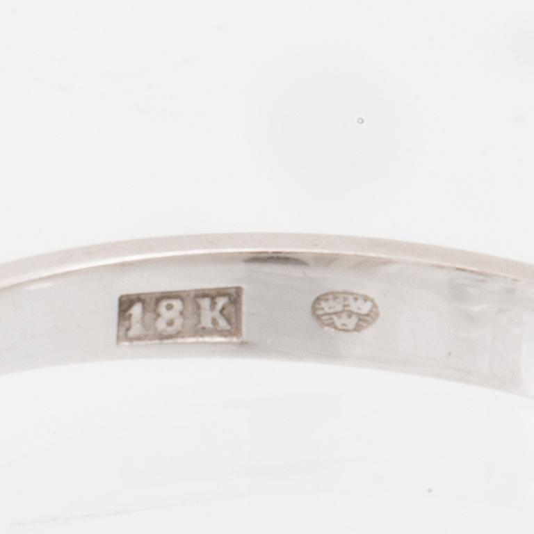 An 18K white gold solitaire ring set with a round brilliant-cut diamond.