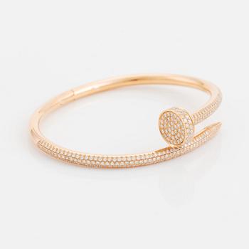 A Cartier "Juste en Clou" bracelet in 18K rose gold set with round brilliant-cut diamonds.