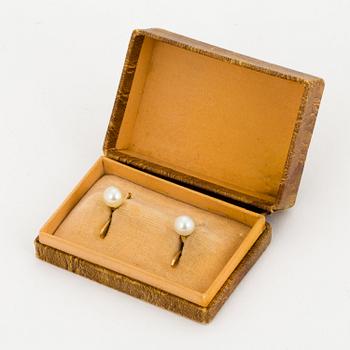 A pair of 18K gold shirt buttons.