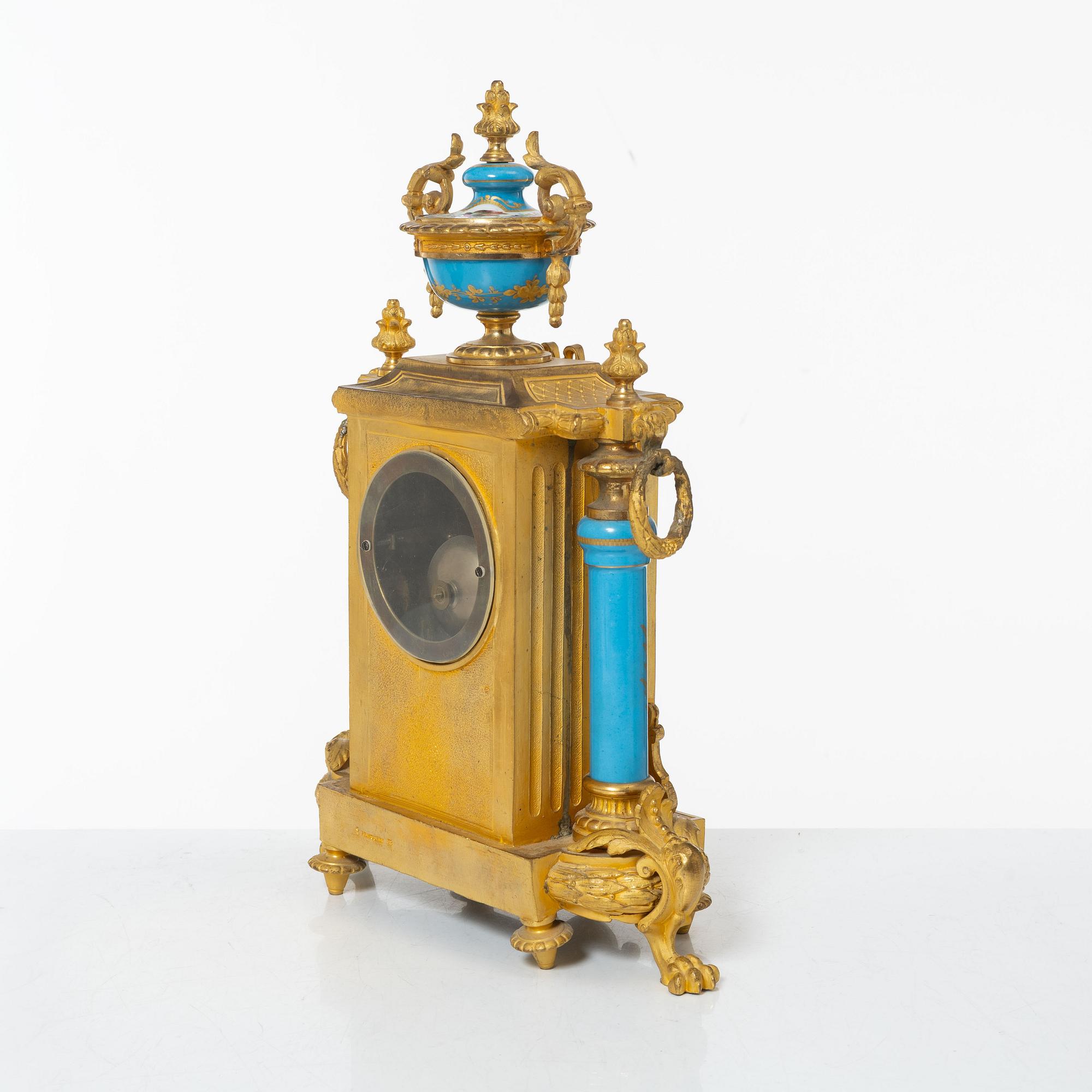 A French Louis XVI-style mantel clock and a pair of candelabra, late 19th Century.