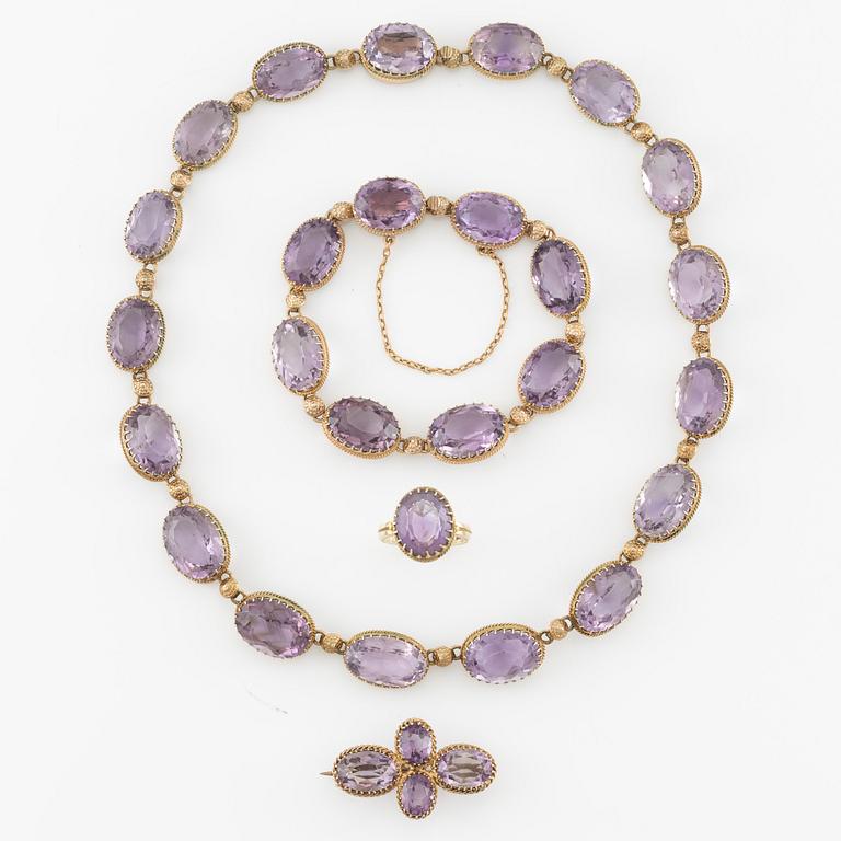 A set with a necklace, a bracelet, a brooch, and a ring.