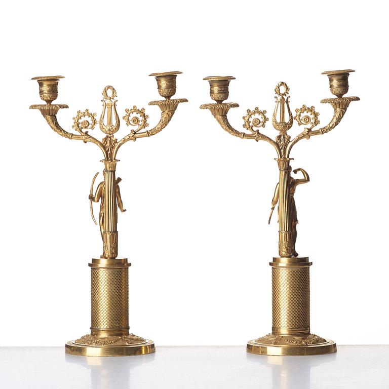 A pair of French Empire two-light gilt bronze candelabra, early 19th century.