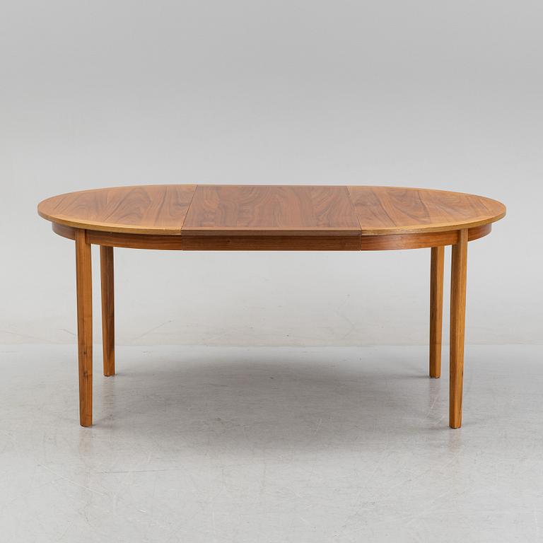 A round walnut veneered dining table.