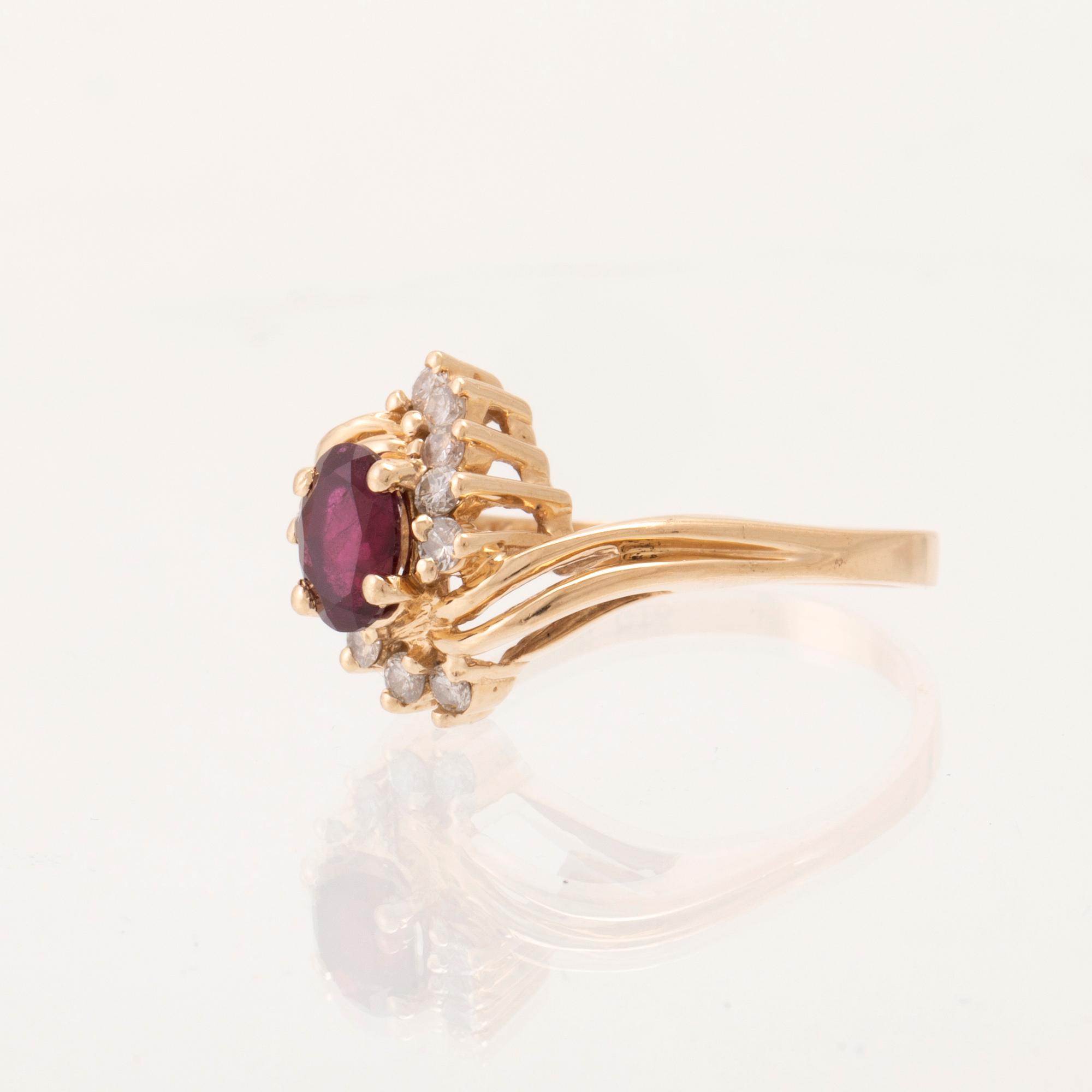 A 14K gold ring set with an oval faceted synthetic ruby and round brilliant-cut diamonds.
