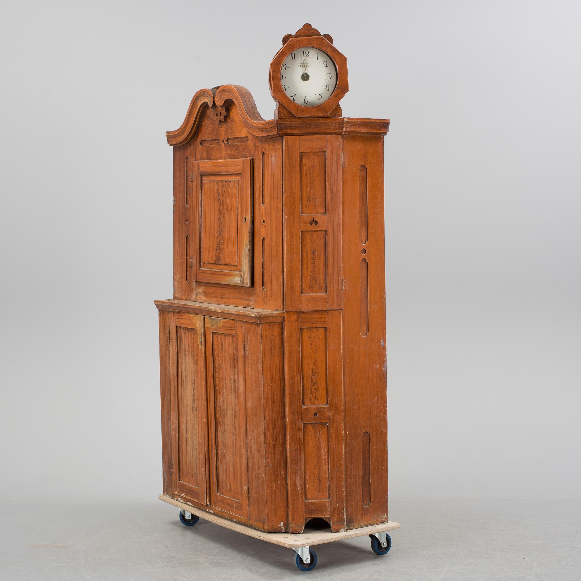 An 18th century cabinet with a clock.