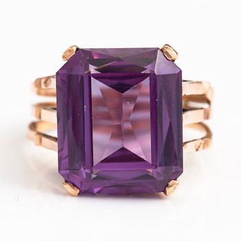 A 9-14K gold ring with a synthetic sapphire.