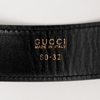 GUCCI, a black patent leather belt.