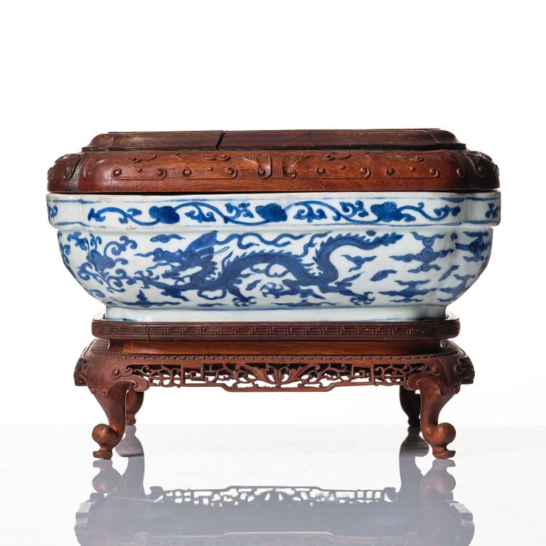 A blue and white quatrefoil dragon box with wooden cover and stand, Ming dynasty, Wanli mark and period (1573-1620).