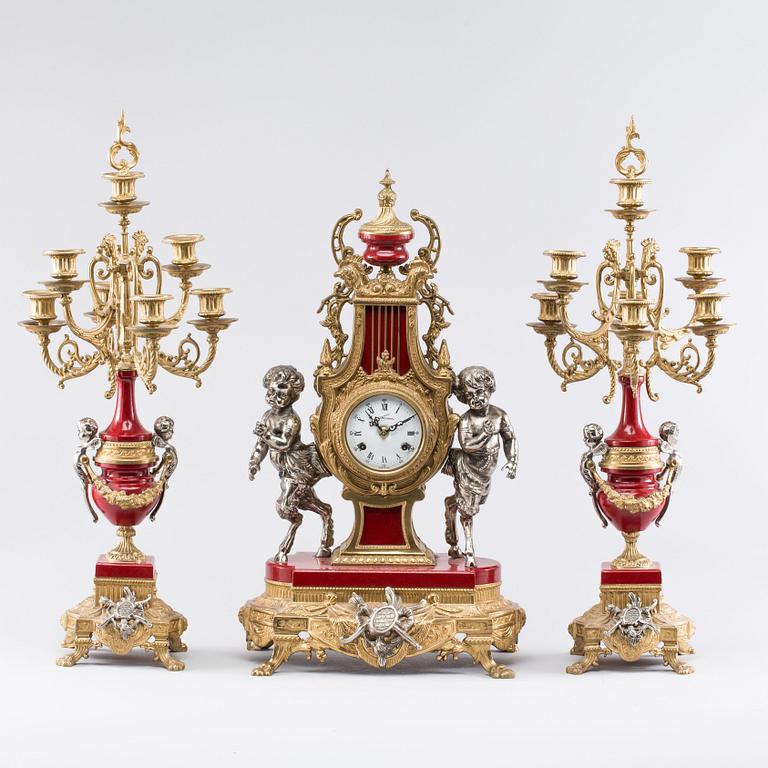 A Franz Hermle mantel clock and a pair of chandelabras. mid/2:nd half of the 20th century.