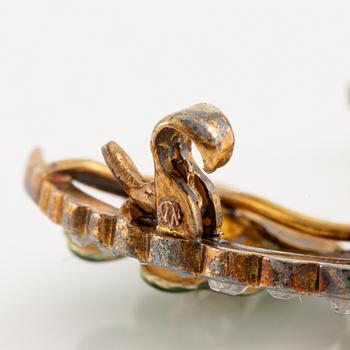 A brooch in the form of a crescent moon in 14K gold  with enamel and rose-cut diamonds.