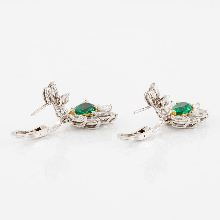 A pair of earrings in 18K white gold with drop-shaped faceted emeralds and diamonds.